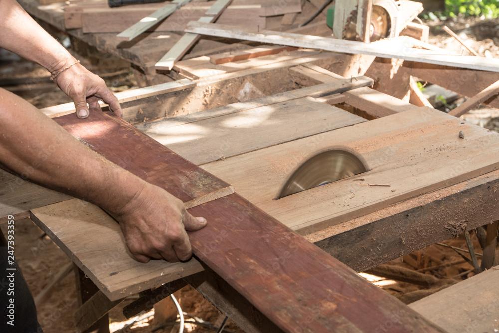 The man use a machine to cut. Circular saw, Power saw , Machine Electronic Table Saw, Sharp Cut Metal Steel Silver in Carpentry Wood Work The man use a machine to cut. Circular saw, Power saw , Machine Electronic Table Saw, Sharp Cut Metal Steel Silver in Carpentry Wood Work