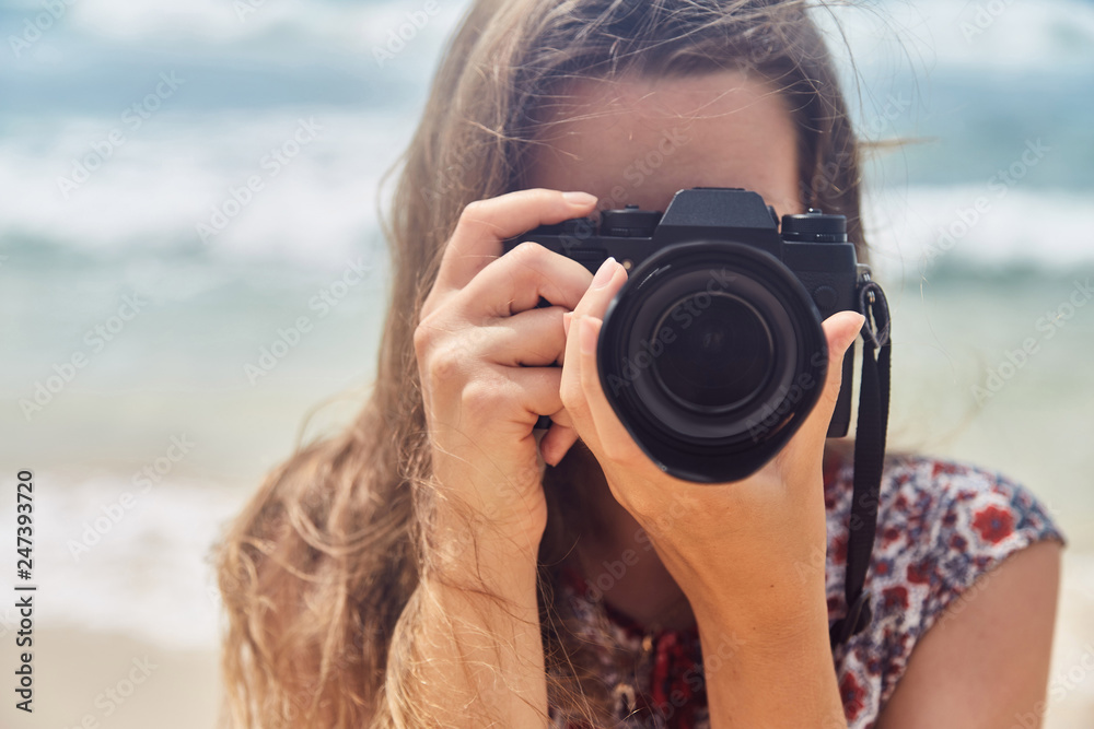 young girl taking pictures on camera in a summer on the beach young girl taking pictures on camera in a summer on the beach