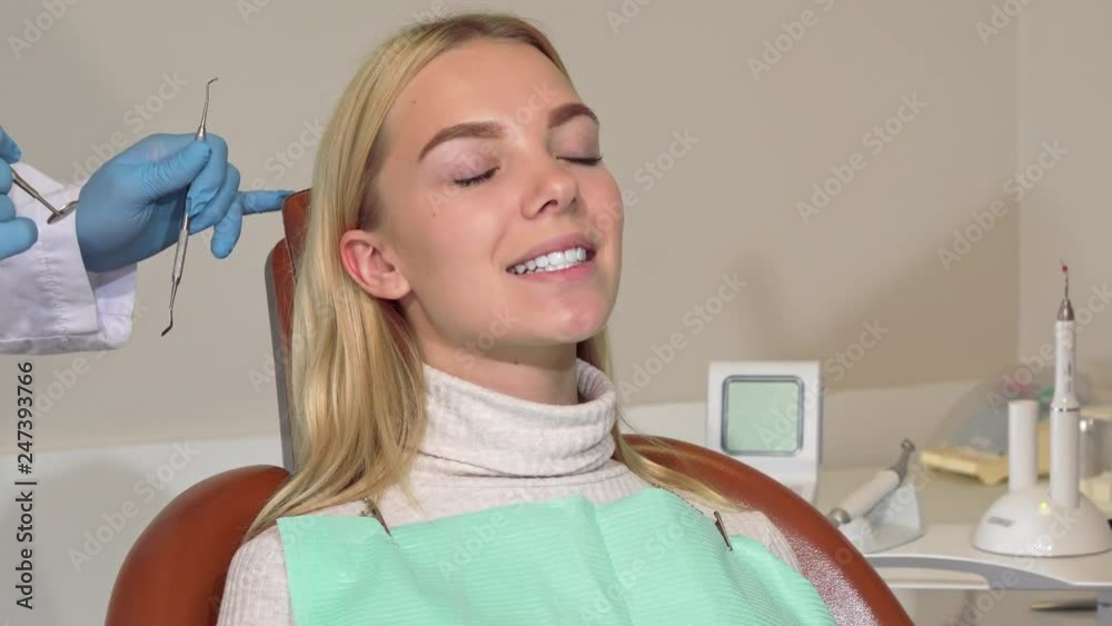 Young woman getting her teeth checked by professional dentist. Cropped shot if a dentist working, examining teeth of a female patient. Treatment, medicine, oral care concept Young woman getting her teeth checked by professional dentist. Cropped shot if a dentist working, examining teeth of a female patient. Treatment, medicine, oral care concept