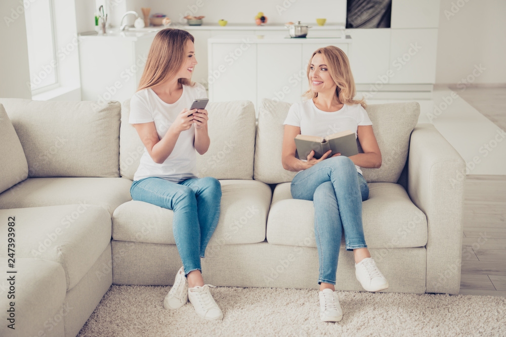 Close up photo of two people pretty mum mommy and teen daughter hands arms telephone diary sharing exchanging information love being together smiling wear white t-shirts jeans sit on comfy sofa Close up photo of two people pretty mum mommy and teen daughter hands arms telephone diary sharing exchanging information love being together smiling wear white t-shirts jeans sit on comfy sofa