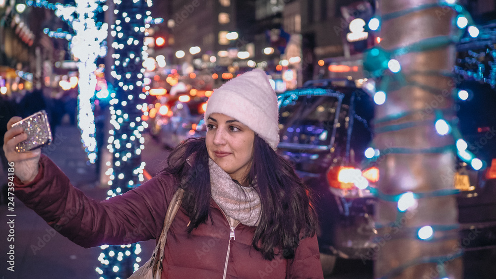 Young woman takes selfies while shopping for Christmas