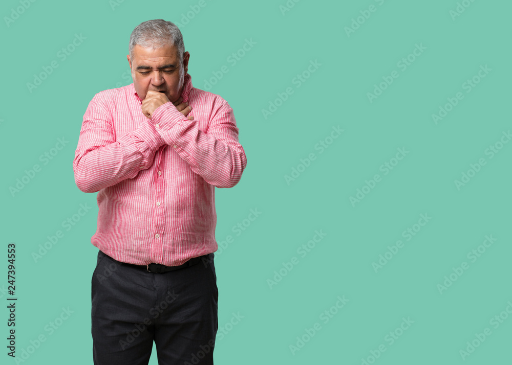 Middle aged man with a sore throat, sick due to a virus, tired and overwhelmed Middle aged man with a sore throat, sick due to a virus, tired and overwhelmed