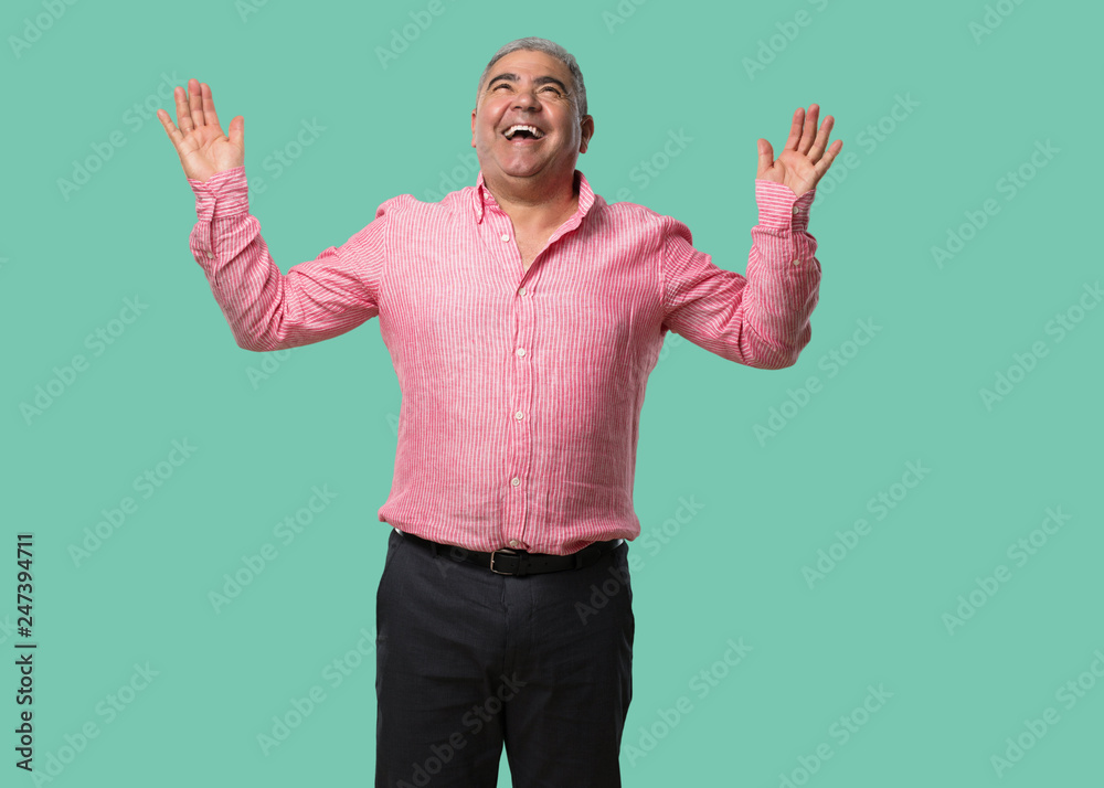 Middle aged man laughing and having fun, being relaxed and cheerful, feels confident and successful Middle aged man laughing and having fun, being relaxed and cheerful, feels confident and successful