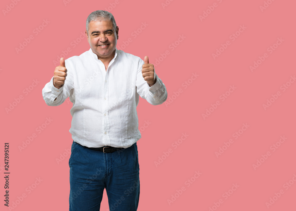 Middle aged man cheerful and excited, smiling and raising her thumb up, concept of success and approval, ok gesture Middle aged man cheerful and excited, smiling and raising her thumb up, concept of success and approval, ok gesture