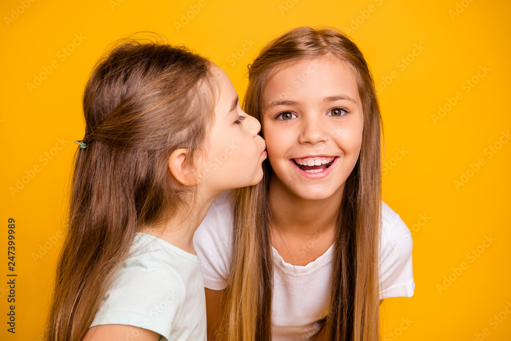 Close-up portrait of two nice cool attractive lovely sweet cheerful cheery positive girlish girls having fun kissing care isolated over bright vivid shine yellow background Close-up portrait of two nice cool attractive lovely sweet cheerful cheery positive girlish girls having fun kissing care isolated over bright vivid shine yellow background