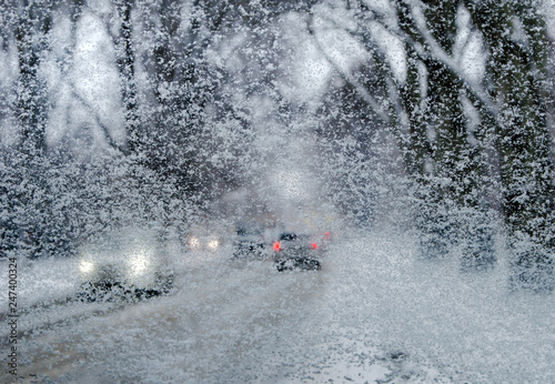 winter road through snow-covered car glass, snowfall