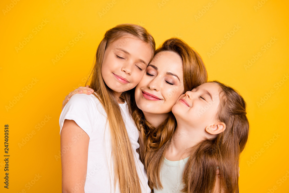 Close-up portrait of three nice cute adorable sweet tender attractive cheerful caucasian people cuddling mum mommy closed eyes isolated over bright vivid shine yellow background Close-up portrait of three nice cute adorable sweet tender attractive cheerful caucasian people cuddling mum mommy closed eyes isolated over bright vivid shine yellow background