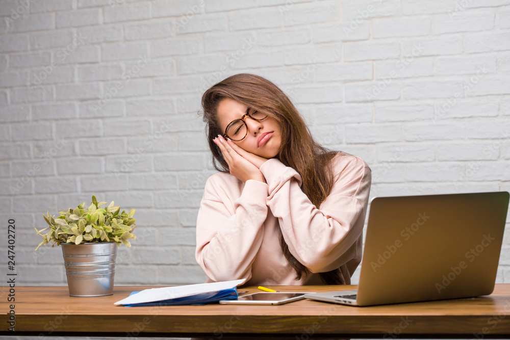 Portrait of young student latin woman sitting on her desk tired and very sleepy, looking comfortable and relaxed, sleep gesture Portrait of young student latin woman sitting on her desk tired and very sleepy, looking comfortable and relaxed, sleep gesture