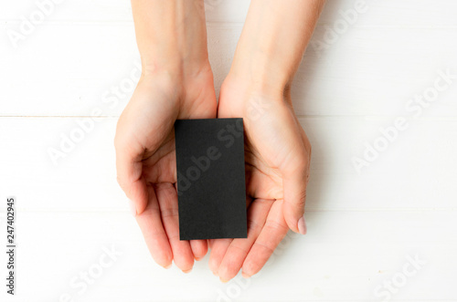 Woman holding black business card in hands. Tamplate for your design.