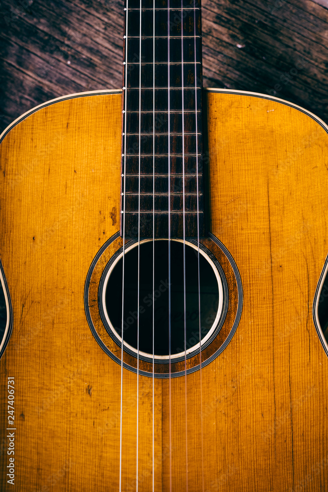 Closeup of wooden acoustic guitar from above.