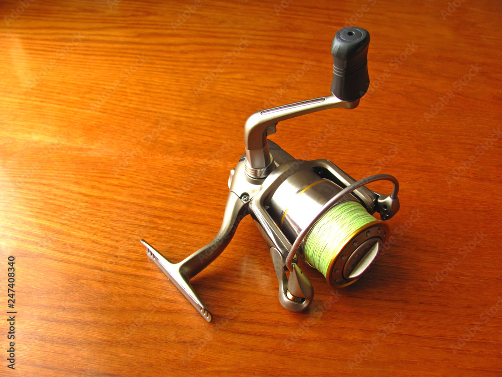 Fixed spool reel is on the table. Top view. Fixed spool reel is on the table. Top view.