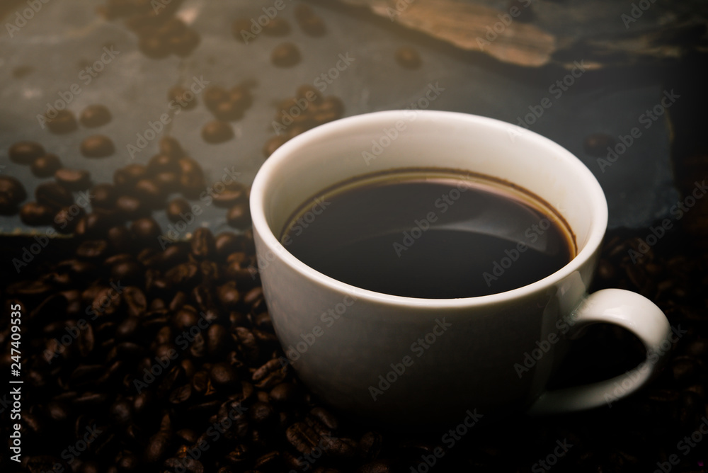 Cup of coffee with smoke and coffee beans on table with coffee beans. Cup of coffee with smoke and coffee beans on table with coffee beans.