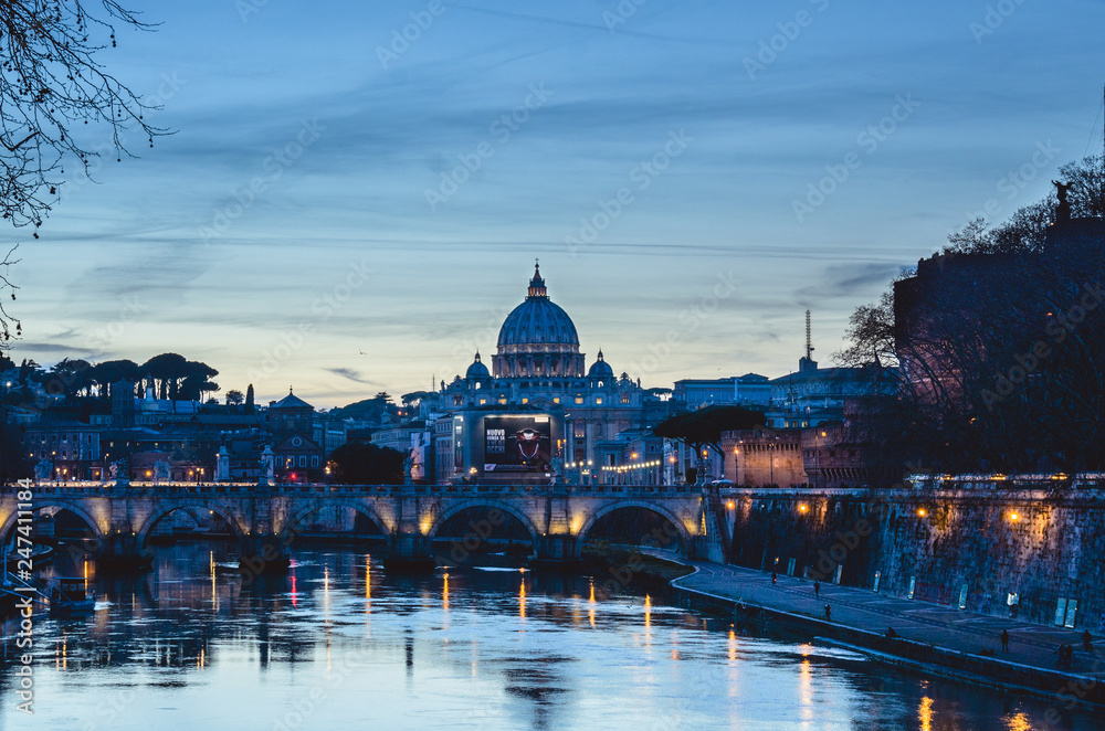A sunset view of St Peters basilica with the Tiber river