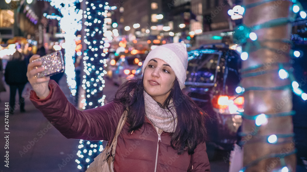 Young woman takes selfies while shopping for Christmas