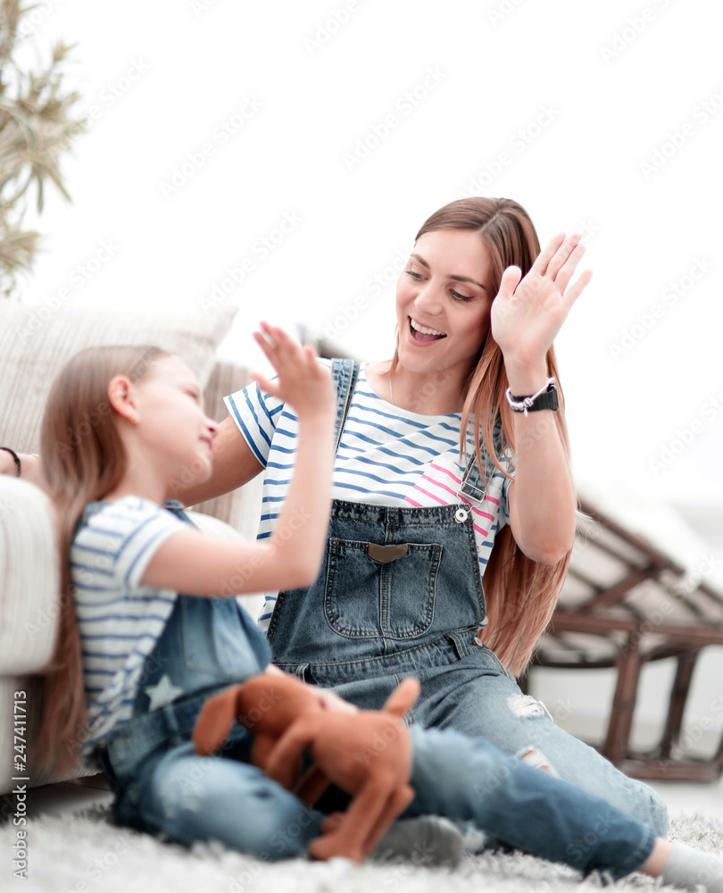 mother and her little daughter give each other a high five