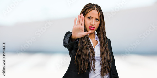 Εκτύπωση καμβά Portrait of a young black business woman serious and determined, putting hand in