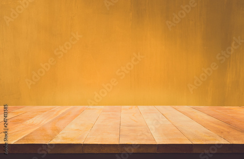 Empty wood table top counter on dark yellow  wall background.For create product display or design key visual