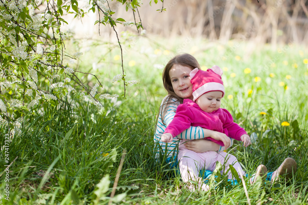 Cute girls in a blooming bird cherry tree garden Cute girls in a blooming bird cherry tree garden
