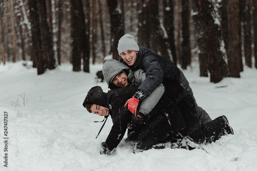 Happy friends in winterwear playing with snow in park. Ukraine 2019