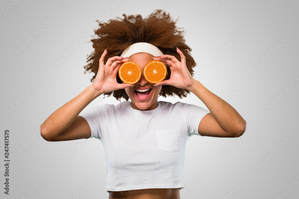young fitness afro woman holding an orange young fitness afro woman holding an orange