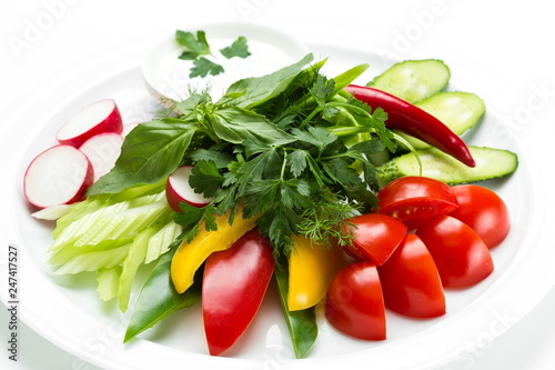 Raw fresh sliced vegetables close up on a plate isolated on white