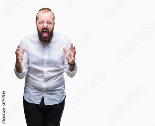 Young caucasian hipster man over isolated background crazy and mad shouting and yelling with aggressive expression and arms raised. Frustration concept.
