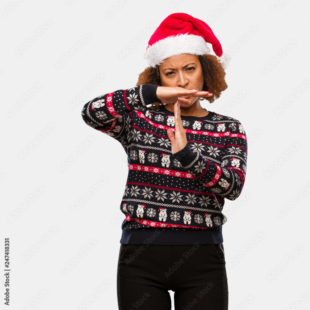 Young black woman in a trendy christmas sweater with print doing a timeout gesture Young black woman in a trendy christmas sweater with print doing a timeout gesture
