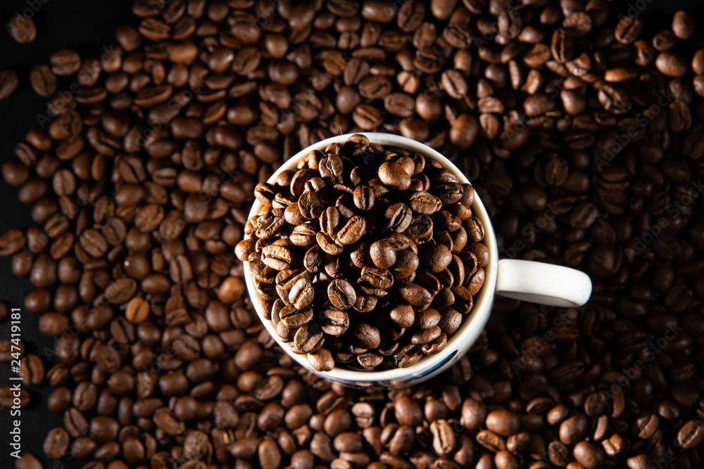 Fototapeta premium white cups with a pattern and grains of coffee on a black background