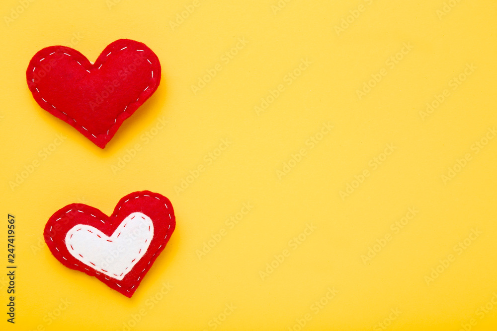 Red fabric hearts on yellow background