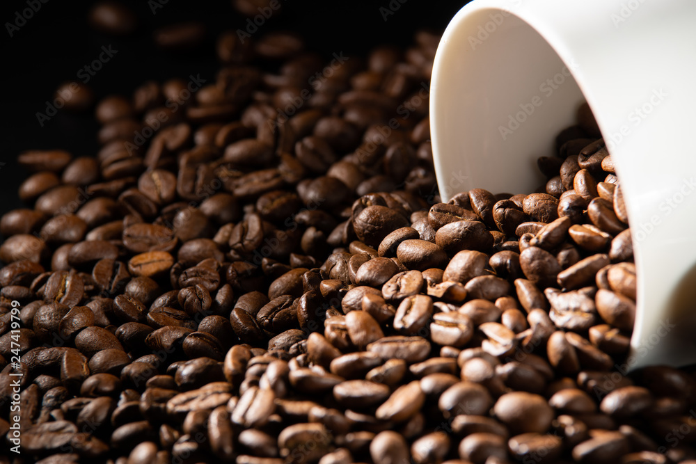 Fototapeta premium white cups with a pattern and grains of coffee on a black background