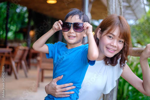Asian mom shot with her son. smile happily face boy with sunglass.