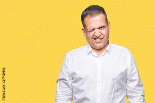 Middle age arab elegant man over isolated background winking looking at the camera with sexy expression, cheerful and happy face.