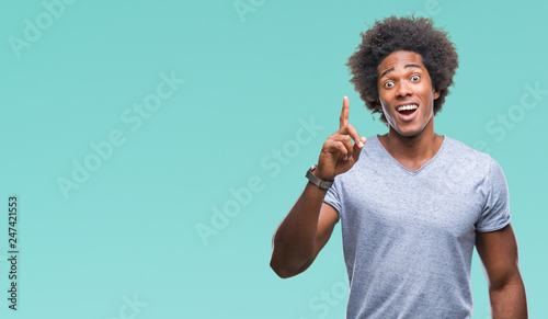 Afro american man over isolated background pointing finger up with successful idea. Exited and happy. Number one. © Krakenimages.com