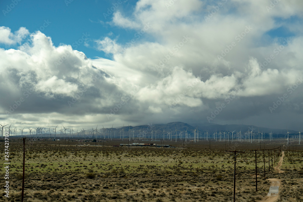 Windmills and clouds over blue sky