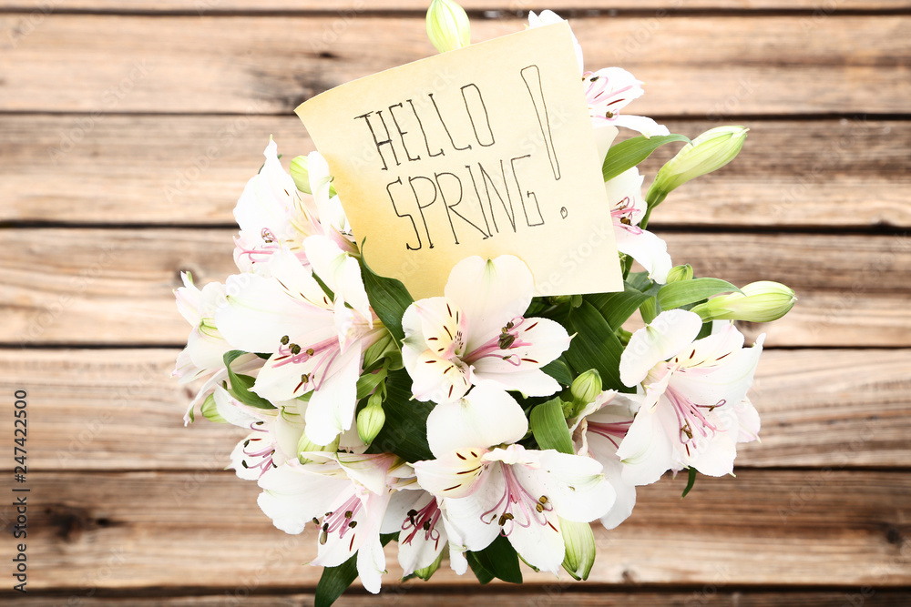 Bouquet of alstroemeria flowers with text Hello Spring on wooden background Bouquet of alstroemeria flowers with text Hello Spring on wooden background