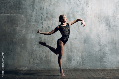 Fototapeta Naklejka Na Ścianę i Meble -  Ballerina female. Young beautiful woman ballet dancer, dressed in professional outfit, pointe shoes and black body.
