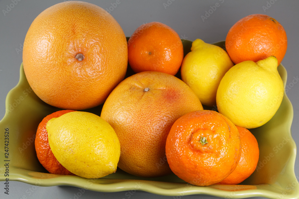 Dish with clementines, grapefruits and lemons on a table Dish with clementines, grapefruits and lemons on a table