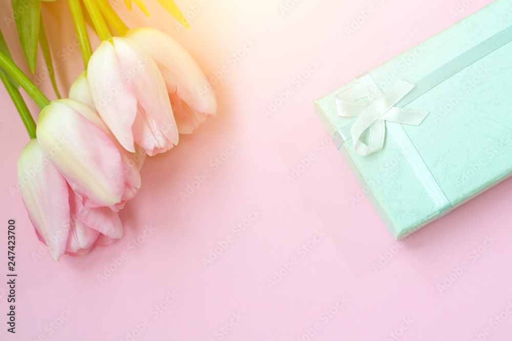 Pink tulips on the pink background with gift box. Flat lay, top view. Valentines background Pink tulips on the pink background with gift box. Flat lay, top view. Valentines background