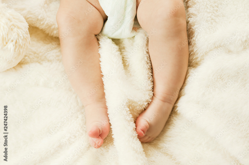gentle healthy legs of a newborn baby gnawing on a plaid. Healthy children concept gentle healthy legs of a newborn baby gnawing on a plaid. Healthy children concept