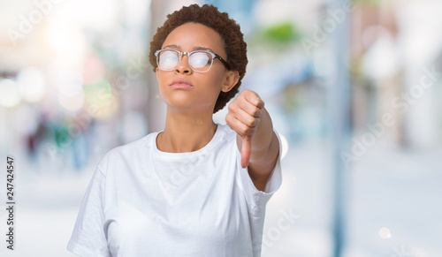 Beautiful young african american woman wearing glasses over isolated background looking unhappy and angry showing rejection and negative with thumbs down gesture. Bad expression.