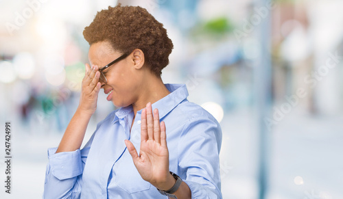 Young beautiful african american business woman over isolated background covering eyes with hands and doing stop gesture with sad and fear expression. Embarrassed and negative concept. © Krakenimages.com