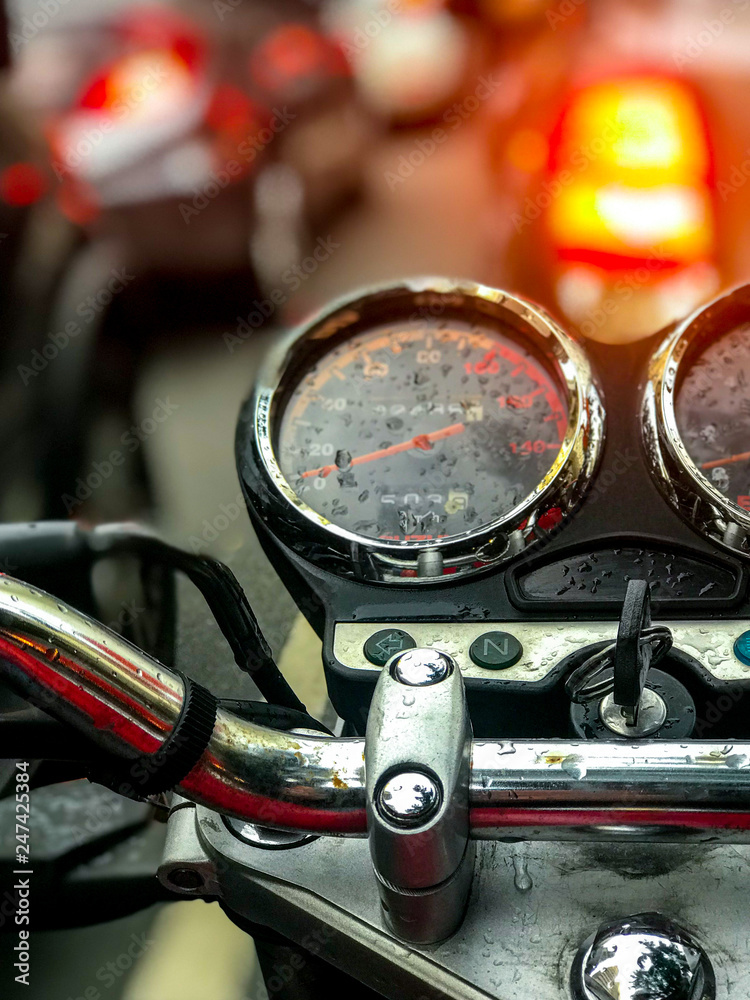 Fototapeta premium Wet motorcycle panel with traffic in the background