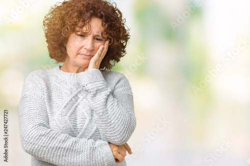 Beautiful middle ager senior woman wearing winter sweater over isolated background thinking looking tired and bored with depression problems with crossed arms.