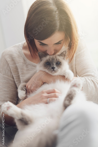 Woman petting her beautiful cat at home
