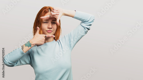 portrait of a pretty redhead girl framing gesture