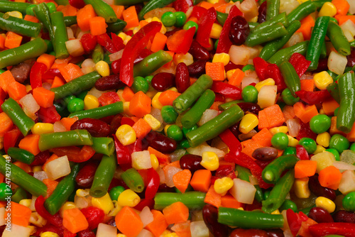 Sliced vegetables, corn, beans, peas, carrots, sweet peppers background.