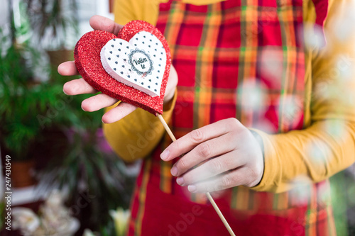 Saleswoman holds beautiful heart stick 