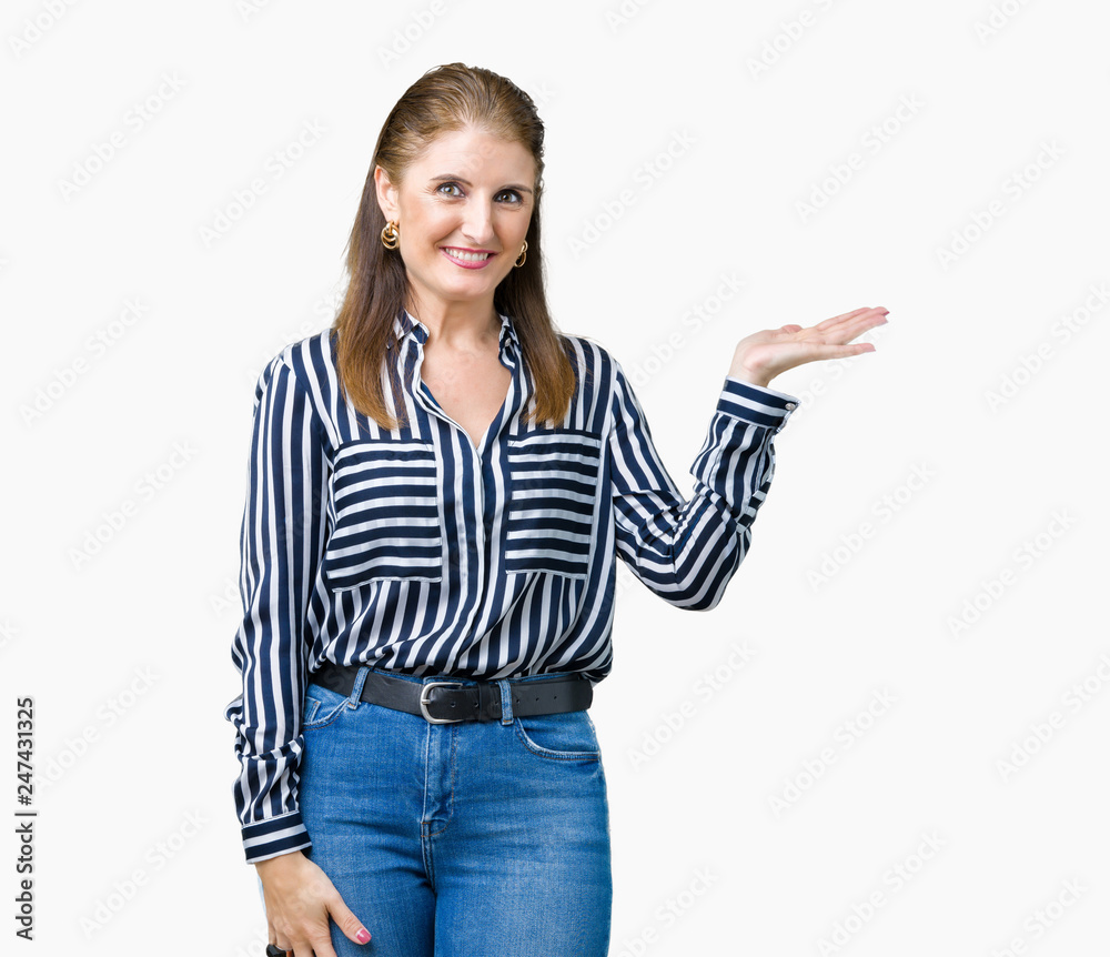 Middle age mature business woman over isolated background smiling cheerful presenting and pointing with palm of hand looking at the camera.