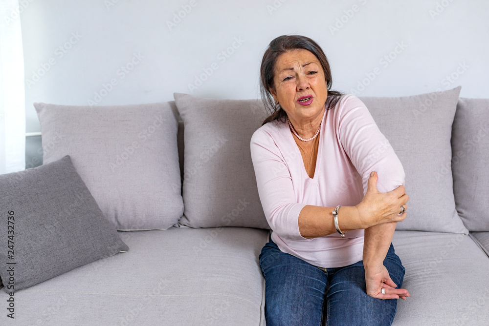 Old age, health problem and people concept - close up of senior woman suffering from pain in hand at home Old age, health problem and people concept - close up of senior woman suffering from pain in hand at home