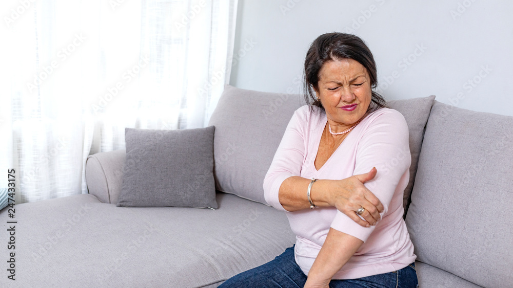 Old woman hand holding her elbow suffering from elbow pain. File contains a clipping path. Senior woman suffering from pain in hand at home. Old age, health problem and people concept Old woman hand holding her elbow suffering from elbow pain. File contains a clipping path. Senior woman suffering from pain in hand at home. Old age, health problem and people concept